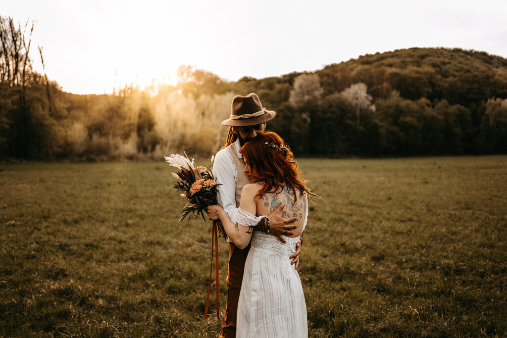 Brautpaar innig auf der Wiese beim sunset