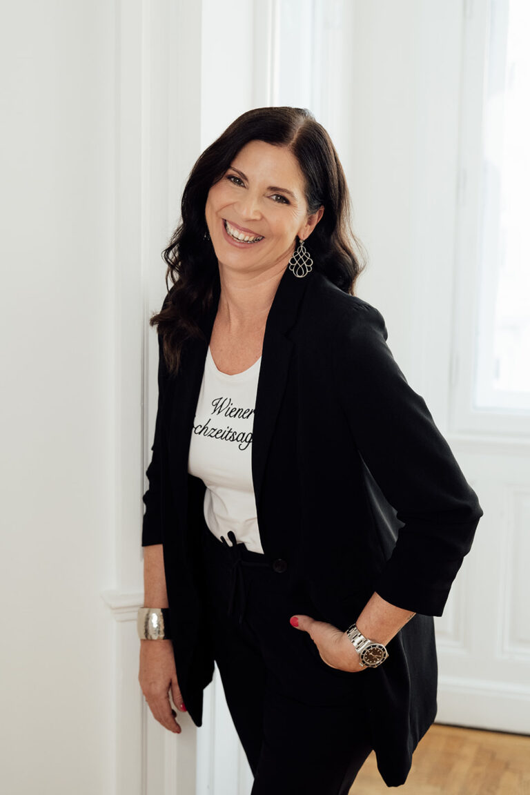 Uschi lachend an die Wand gelehnt