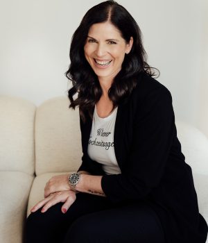 Uschi sitzt auf Couch und lächelt